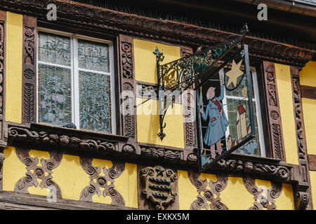 Close up of windows and sign designed by Hansi, Maison a l'Etoile, 42 Rue du General de Gaulle, Riquewihr, Alsace, France Stock Photo