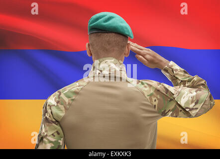 Dark-skinned soldier in hat facing national flag series - Armenia Stock Photo