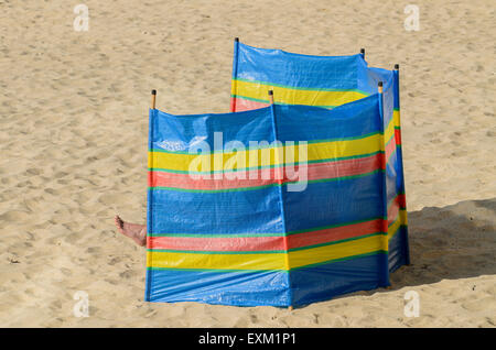 A foot protruding from the cover of a wind break on Porthmeor Beach, St Ives, Cornwall, England, U.K. Stock Photo
