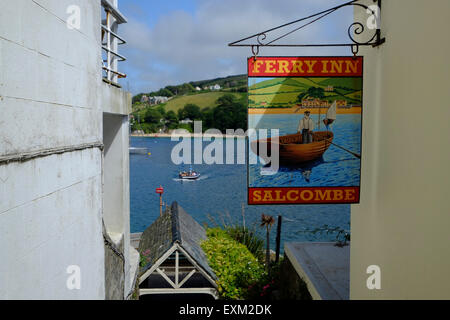 Salcombe, Devon, UK. The Ferry Inn Pub sign with the Ferry approaching the Salcombe Landing in the background Stock Photo