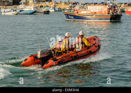 RNLI inshore Lifeboat passing the Offshore Lifeboat in the harbour, St Ives, Cornwall, England, U.K. Stock Photo