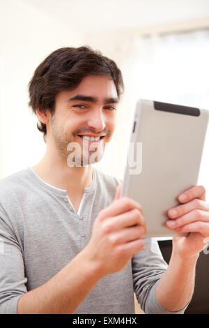 View of a Young smiling man using a tablet Stock Photo
