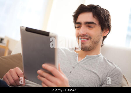 View of a young relaxed men in a sofa using tablet Stock Photo