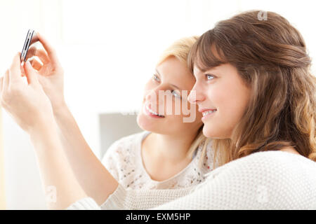 View of Girls on sofa taking selfie picture with smartphone Stock Photo