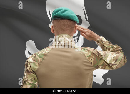 Dark-skinned soldier in hat facing flag series - Jolly Roger Stock Photo