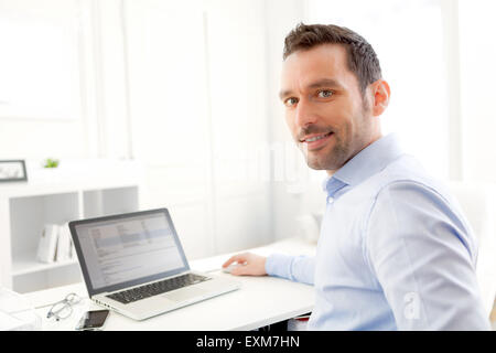 View of a Young business man working at home on his laptop Stock Photo