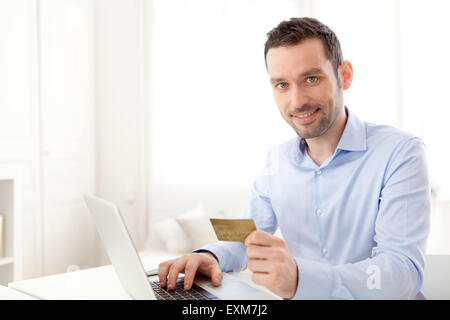 View of a Young business man paying online with credit card Stock Photo