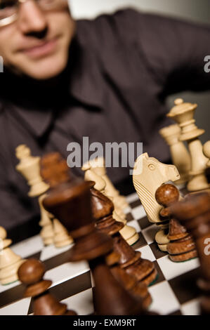 Chess master thinking before making a move (shallow Dof, focus on chess piece) Stock Photo