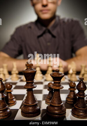 Chess master thinking before making a move (shallow Dof, focus on front chess piece) Stock Photo