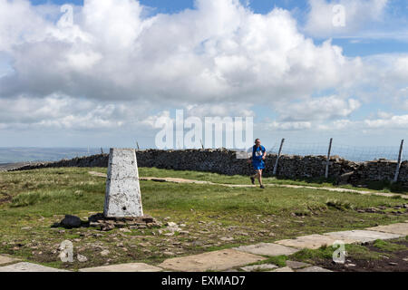 Three Peaks Challenge Runner and the Summit Trig of Buckden Pike, Upper Wharfedale, Yorkshire Dales UK Stock Photo