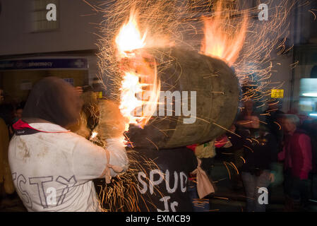 Intermediate burning barrel being carried through the street to mark Bonfire Night, 5 November, at the Tar Barrels festival, Ottery St Mary, Devon, England Stock Photo