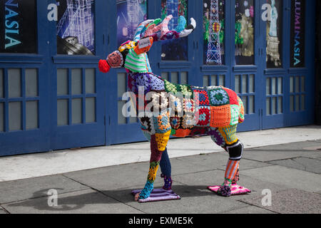 Decorated wire-framed woollen deer, 'Yarn Bombed' anaimal covered with crocheted wool squares of various colours of knitted wool. Blackpool, UK Stock Photo