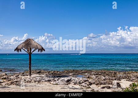 Shoreline of Cozumel looking out toward the Caribbean sea with some beach and an old umbrella. Stock Photo