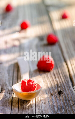 Rasberry in wooden spoon isolated on vintage wooden background Stock Photo