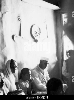 Jawaharlal Nehru sitting in Mahatma Gandhi's hut at Sevagram Ashram after he had expired ; March 1948 Stock Photo