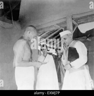 Jawaharlal Nehru and Mahatma Gandhi in front of his hut at Sevagram Ashram ; 1938; c Rajkumari Amrit Kaur NO MR Stock Photo