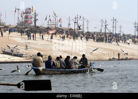 Devotees sitting in boat arriving at confluence of Ganges; Yamuna and mythical Saraswati rivers Ardh Kumbh Mela Allahabad Stock Photo