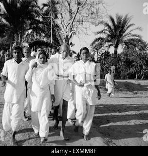 Mahatma Gandhi ; supported by Amtus Salam and Manu Gandhi ; walking with others through the riot effected Noakhali East Bengal Stock Photo