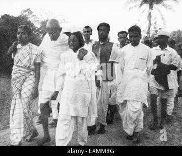 Mahatma Gandhi supported Amtus Salam another woman ; walking with others through riot effected Noakhali East Bengal Stock Photo