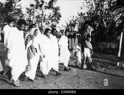 Mahatma Gandhi supported Amtus Salam and another woman ; walking with others through the riot effected Noakhali East Bengal Stock Photo