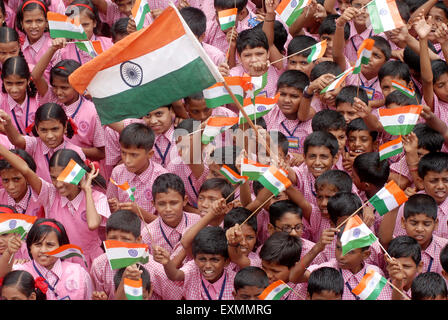 School children celebrate Indian Independence Day by waving Indian tri color flag in Bombay Mumbai ; Maharashtra ; India Stock Photo