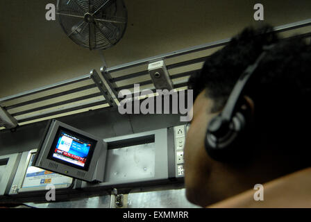 Passenger watching television introduce by Indian Railways on experimental air conditioned bogie Mumbai Stock Photo