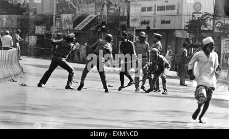 Policemen hitting man with sticks Bombay Mumbai Maharashtra India Stock Photo