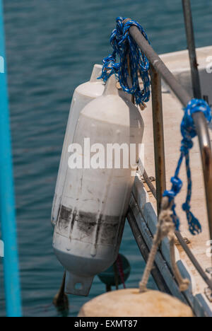 White buoys hanging on the aboard of fishing boat. Closeup Stock Photo