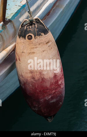 Old buoy hanging on the aboard of fishing boat. Closeup Stock Photo