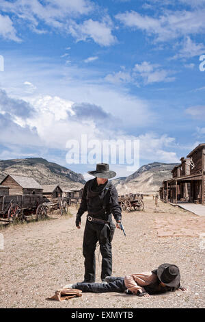 Two cowboys in the street, one on the ground and the other holding a gun on him, Old Trail Town, Wyoming, USA. Stock Photo