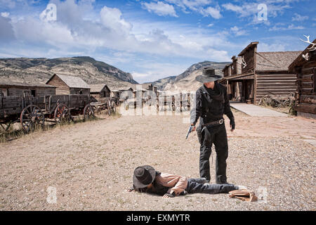 Two cowboys in the street, one on the ground and the other holding a gun on him, Old Trail Town, Cody, Wyoming, USA. Stock Photo