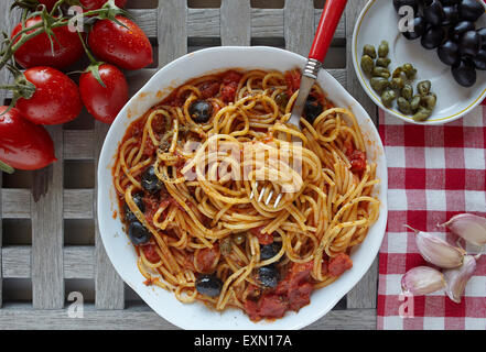 italian food: pasta with tomatoes, olives and capers, called puttanesca Stock Photo