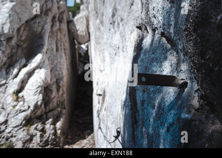 Hiking path through a rock passageway in the Chartreuse mountains, French Alps, with projections for attaching cables. Stock Photo