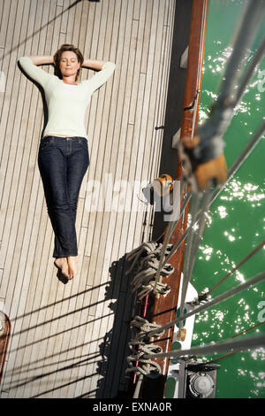 https://l450v.alamy.com/450v/exna0r/relaxed-mature-woman-lying-on-deck-of-a-sailing-ship-exna0r.jpg