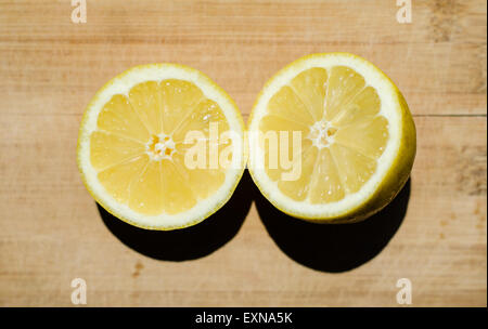 cut lemon with basil leafs on a wooden desk Stock Photo