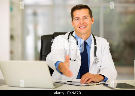 friendly medical doctor offering handshake in office Stock Photo