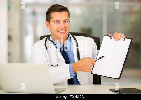 smiling doctor showing clipboard with blank paper Stock Photo