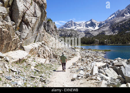 Man hikes by Long Lake in Little Lakes Valley in Rock Creek Canyon in the Eastern Sierra Stock Photo