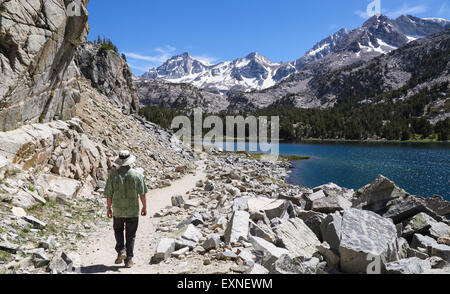 Man hikes by Long Lake in Little Lakes Valley in Rock Creek Canyon in the Eastern Sierra Stock Photo