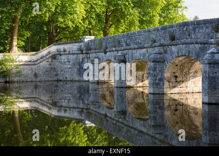 Old stone bridge reflecting in River Cosson at Chateau de Chambord, Loire Valley, France
