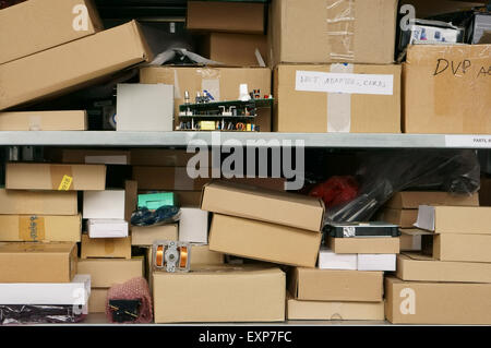 Metal racks with spare parts in cardboard  boxes for repair of radio electronics. Warehouse of the service center. Mass producti Stock Photo