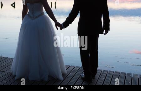 Vintage photo of silhouettes of wedding couple photographed in outdoor. Beautiful young people in their wedding day Stock Photo