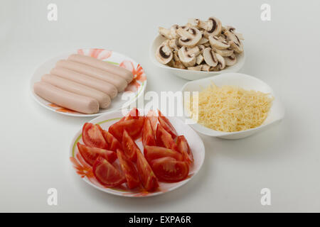 ingredients for preparation of pizza are spread out on plates and are ready to use Stock Photo