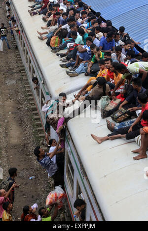 Dhaka, Bangladesh. 16th July, 2015. Bangladeshi passengers sit on the roof of a train, as they head to their homes to celebrate Eid al-Fitr in Dhaka, Bangladesh, Thursday, July 16, 2015. Hundreds of thousands of people working in Dhaka plan to leave for their home towns to celebrate with their family the upcoming Eid al-Fitr. Stock Photo