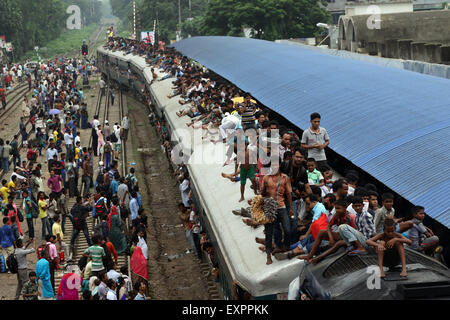 Dhaka, Bangladesh. 16th July, 2015. Bangladeshi passengers sit on the roof of a train, as they head to their homes to celebrate Eid al-Fitr in Dhaka, Bangladesh, Thursday, July 16, 2015. Hundreds of thousands of people working in Dhaka plan to leave for their home towns to celebrate with their family the upcoming Eid al-Fitr. Stock Photo