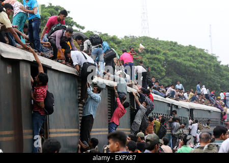 Dhaka, Bangladesh. 16th July, 2015. Bangladeshi passengers sit on the roof of a train, as they head to their homes to celebrate Eid al-Fitr in Dhaka, Bangladesh, Thursday, July 16, 2015. Hundreds of thousands of people working in Dhaka plan to leave for their home towns to celebrate with their family the upcoming Eid al-Fitr. Stock Photo