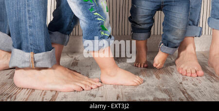 dad, mom and daughters barefoot in jeans Stock Photo