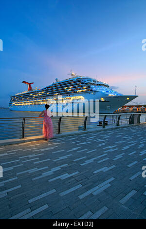 Woman admiring cruise ship from  Bahia Urbana (Urban Bay), Old San Juan, Puerto Rico Stock Photo