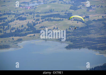 Paraglider flying over Bavarian lake Forggensee Stock Photo