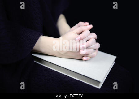 female hands on a closed book Stock Photo